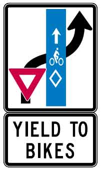 Sign showing the car turning right and entering the right turn lane to yield to the bicycles in the bike lane.