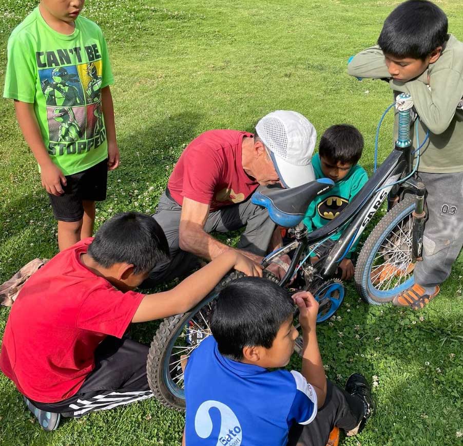 Kevin being the maestro bicycle repair whiz teaching the kids and salvaging parts for youth bicycles as well as their inventory of older mountain bikes.